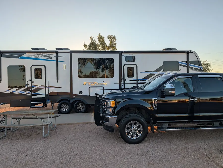 Travel trailer and tow truck detailed at sunset